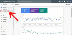 این تصویر یک اسکرینشات از رابط کاربری Google Search Console را نشان میدهد که در آن صفحه "بررسی اجمالی" با نمودارها و دادههای عملکرد سایت قابل مشاهده است. در سمت چپ، یک فلش قرمز رنگ بزرگ به طور خاص به گزینه "URL Inspection" در منوی ناوبری اشاره میکند